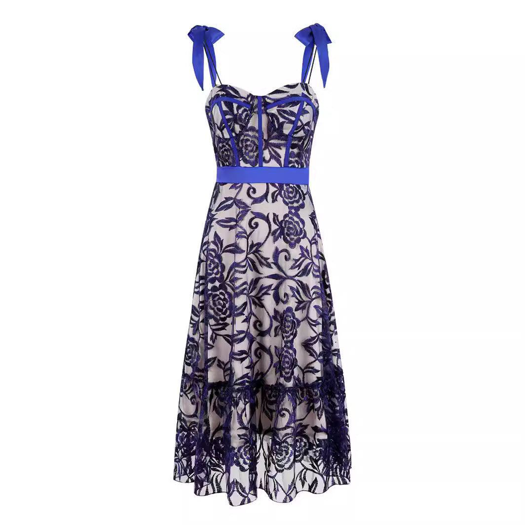 Front view of dress: Indulge in luxury with our Elegant Long Dress. The ornate blue embroidered top layer and delicate skinny straps with ribbons exude sophistication. The ribbon belt adds a touch of elegance while the low-cut front and back add playful allure. Perfect for special occasions.